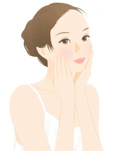 顔に手を当てて肌を気にしている女性