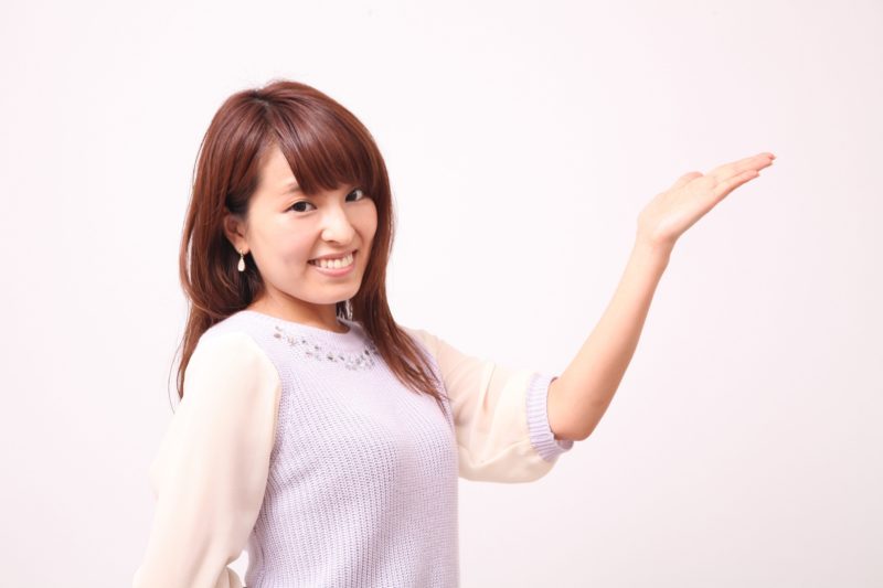 手を上に向けている白い服の女性