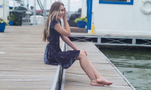 桟橋に座る青いドレスの女性