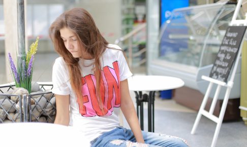 カフェのテラスでぐったりする女性