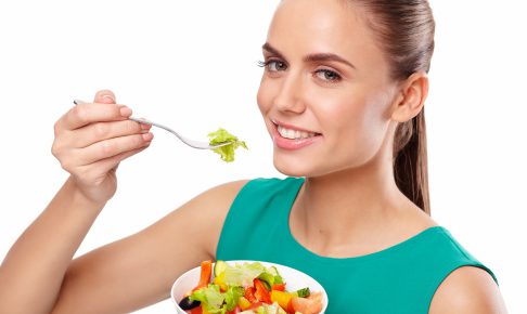 サラダを美味しそうに食べる女性