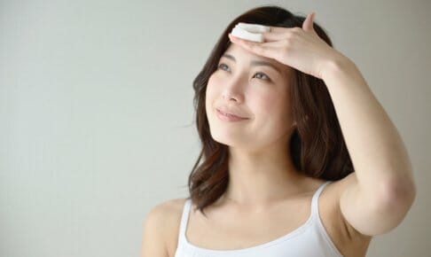 コットンをおでこに当てる女性
