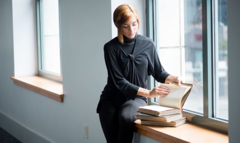 窓際で本を読む女性