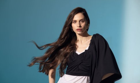 髪の毛がなびいているオシャレな服の女性