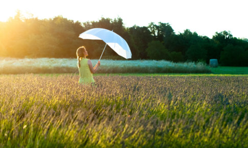 ラベンダー畑にいる傘を持った女性