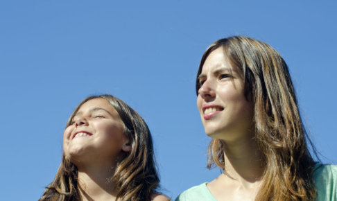 快晴の青空を眺めている母と娘