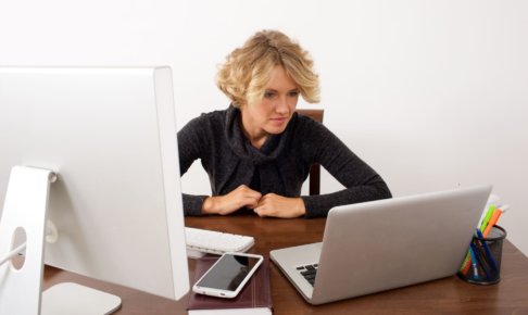 パソコンを見比べている女性