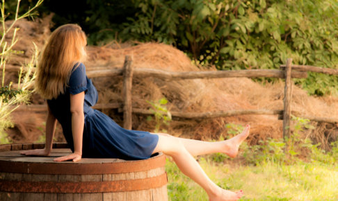 樽に腰かけている女性の画像