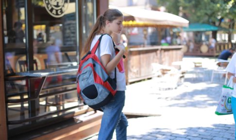 リュックサックを背負いながら街を歩く外国人女性