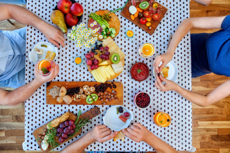 フルーツを食卓（テーブル）で食べている人々の画像