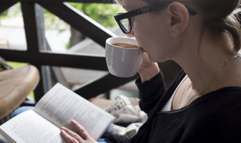 ティータイム中に読書する女性