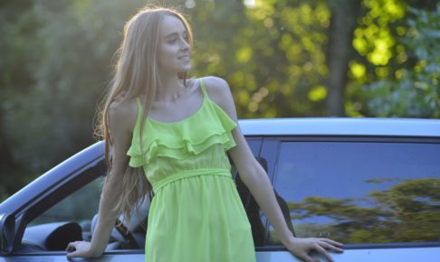 車と黄色のワンピースを着用した外国人女性