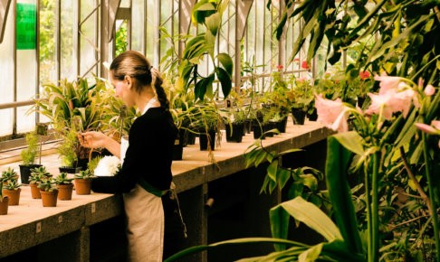 草花を手入れしている花屋の外国人女性