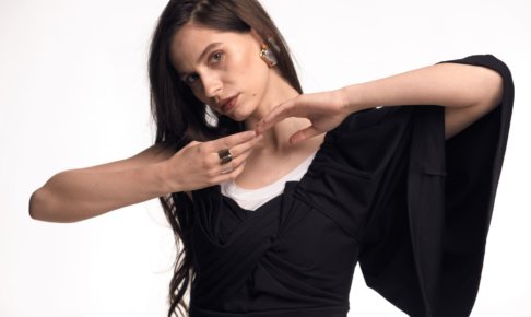 白い服と黒い服を着用している髪の毛を結んでいない長髪の外国人女性