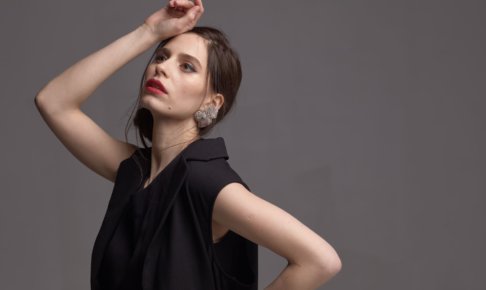 額に手を当てている黒い服を着用した外国人女性