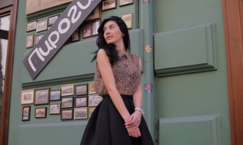 緑の写真や看板の前で佇む女性