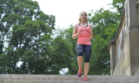 木々がある階段をジョギングしている女性