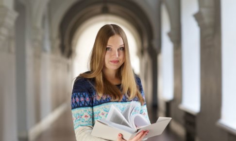 本を開いて立っている女性