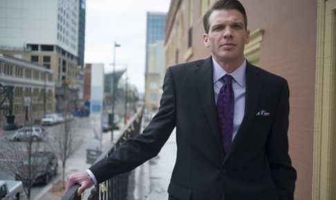 手すりに手を掛けているスーツを着用した男性