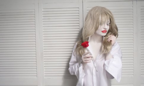 赤い花を持っている白い肌の女性の画像