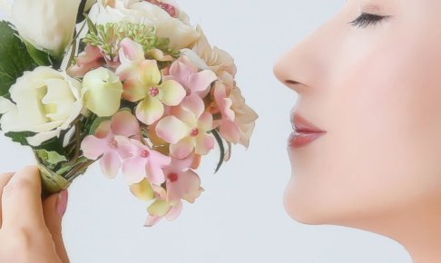 花のブーケを顔に近づけている女性