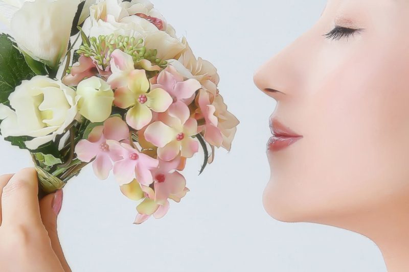 花のブーケを顔に近づけている女性