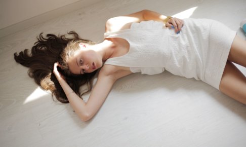 頭に手を当てて横たわっている外国人モデル