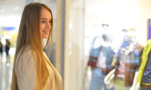 洋服のショーウインドーを眺めている女性