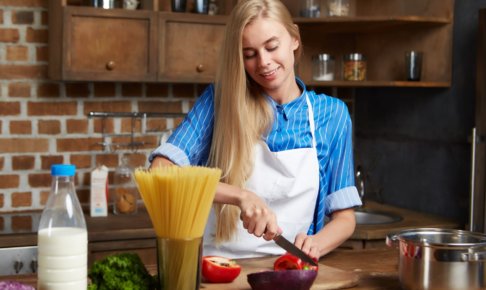 パプリカを切っているキッチンの女性