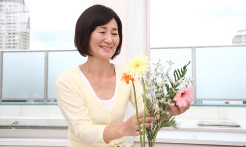花を活けているシニア女性