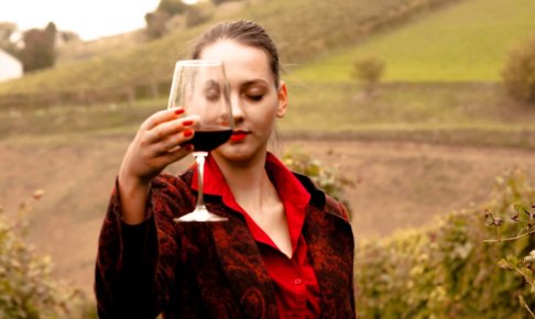 赤ワインを片手に飲んでいる赤い服の女性