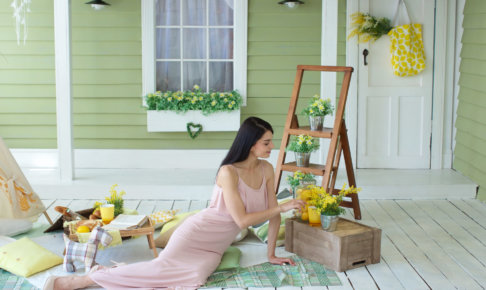 玄関先でお花を飾ってピクニックしている女性