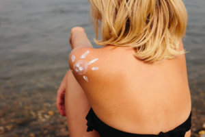 肩に日焼け止めで太陽の絵が描かれている水着を着用している女性