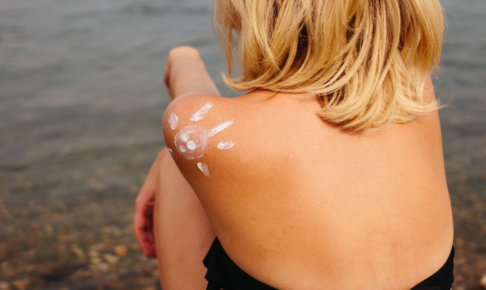 肩に日焼け止めで太陽の絵が描かれている水着を着用している女性