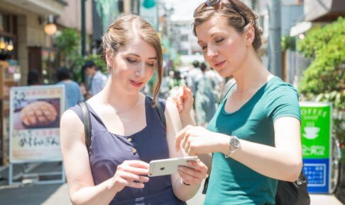 強い日差しの中お昼ご飯を探している女性2人