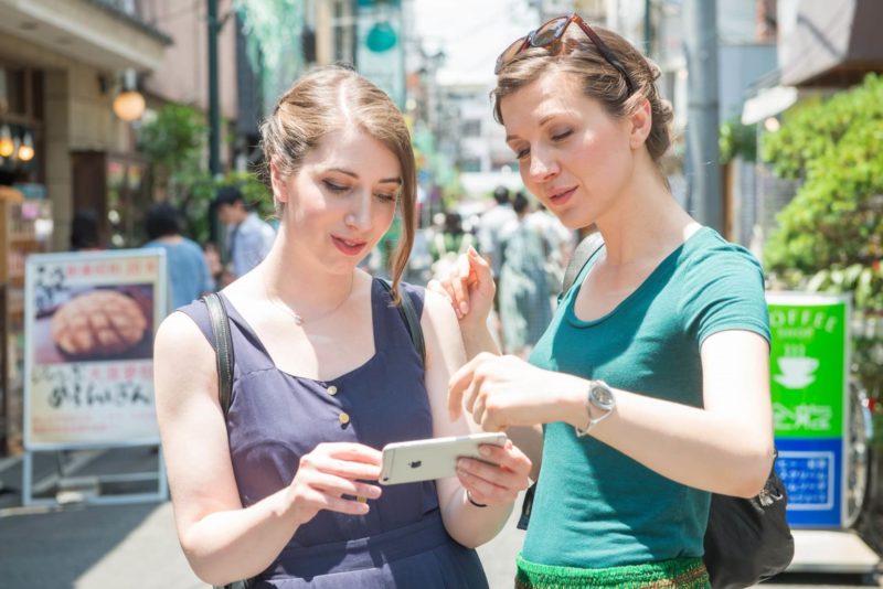 強い日差しの中お昼ご飯を探している女性2人