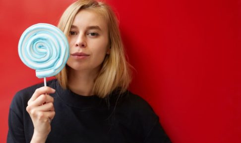 青いキャンディーを舐めている女性