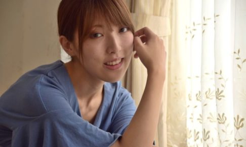 窓際に肘をついている青い服を着用した女性