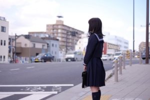 横断歩道の前に立つ女子高生