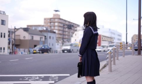 横断歩道の前に立つ女子高生