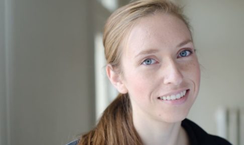 髪の毛を1つ結んで笑顔を見せている外国人女性