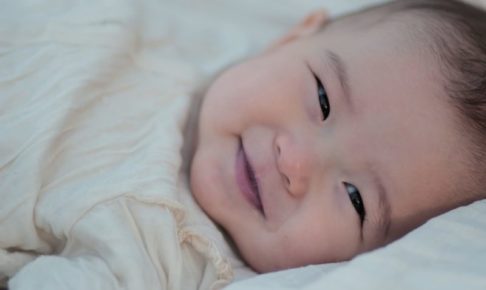 赤ちゃん横向き笑顔背景暗め
