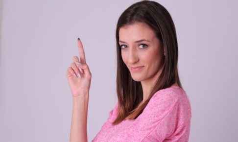 長い人差し指を指して決めポーズをしている女性