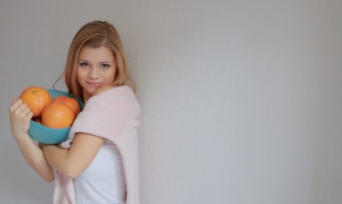 大きなオレンジを持って部屋に行こうとしている女性