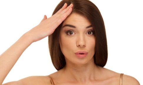 おでこに手を当てておどける白人女性