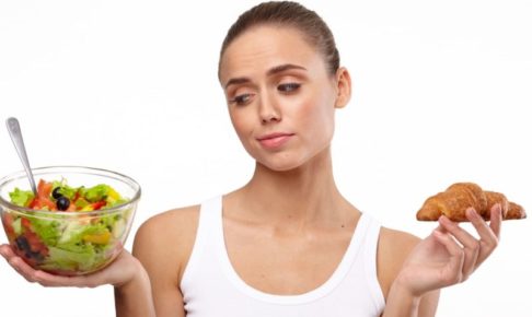 右手にサラダ左手にパンを持つ外国人女性