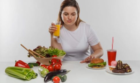 一生懸命誘惑に負けないで野菜を摂ろうとしている女性