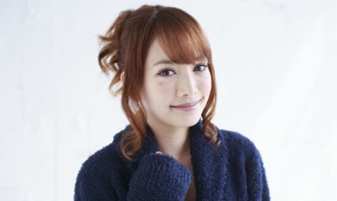 髪を上げて紺のバスローブを着て微笑んでいる女性