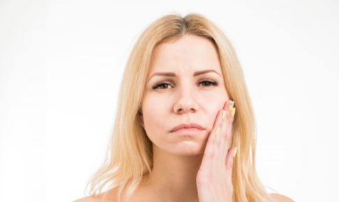 左手を頬に当て悲しげな外国人女性