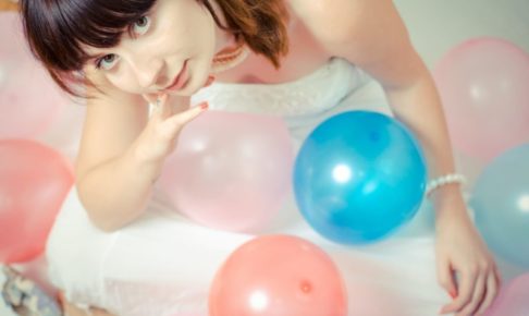 風船と一緒にいる上目遣いのウエディング姿の女性